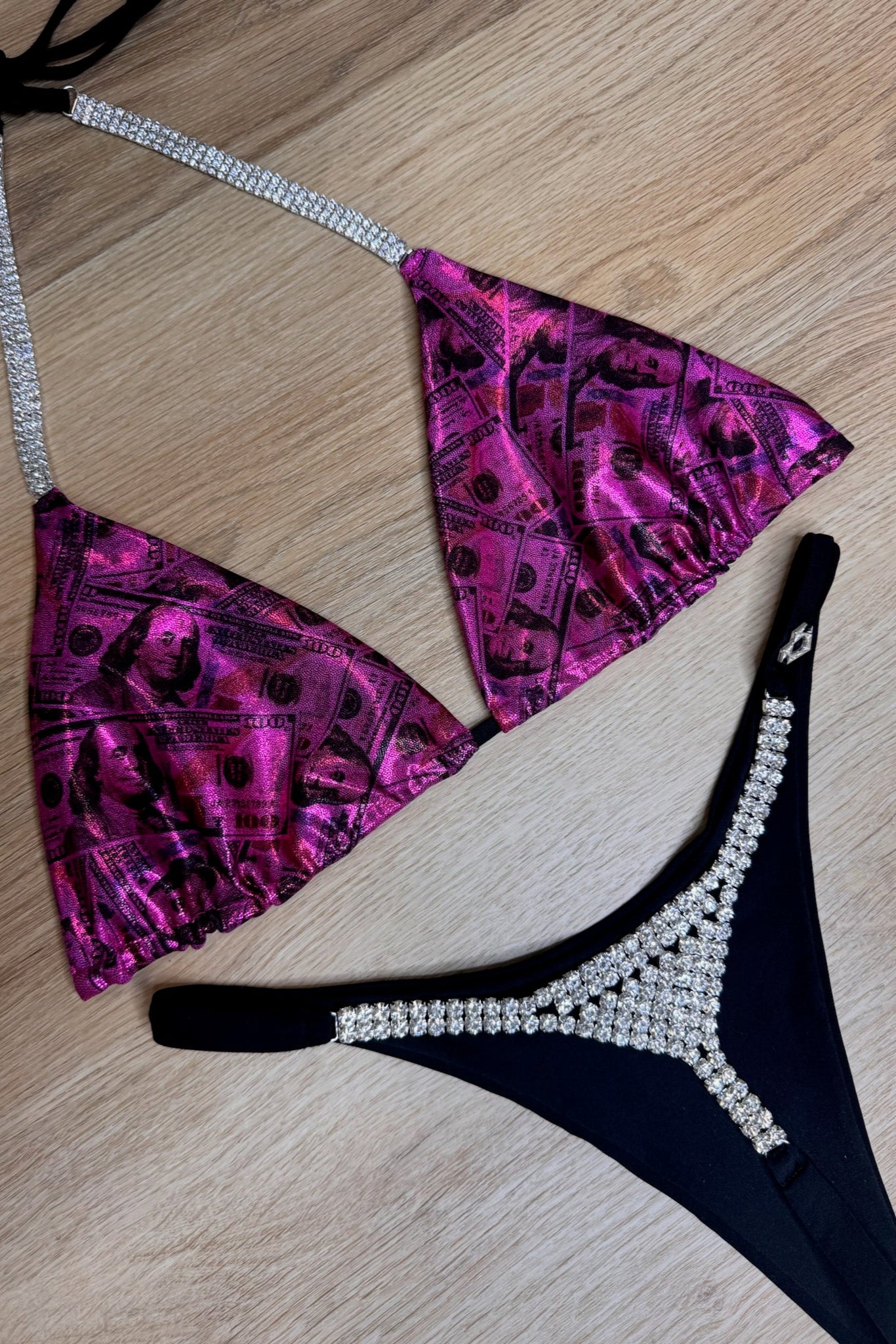 Purple and black bikini set with rhinestone details on a wooden surface